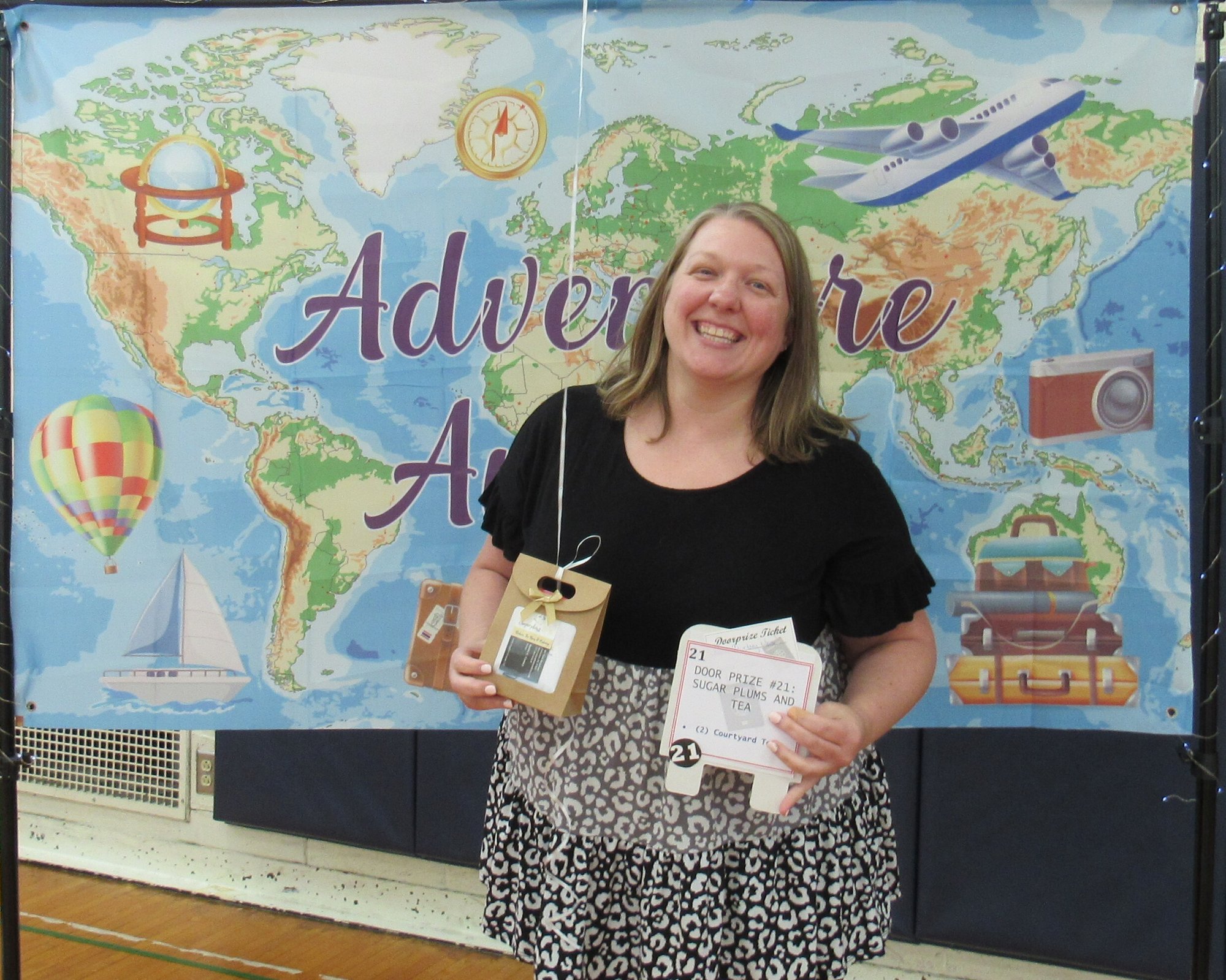 Smiling woman holding gift package in front of banner showing a map of the world. Smiling woman holding gift package in front of banner showing a map of the world.