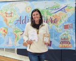 Smiling woman holding gift package in front of banner showing a map of the world. Smiling woman holding gift package in front of banner showing a map of the world.