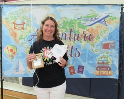 Smiling woman holding gift package in front of banner showing a map of the world.