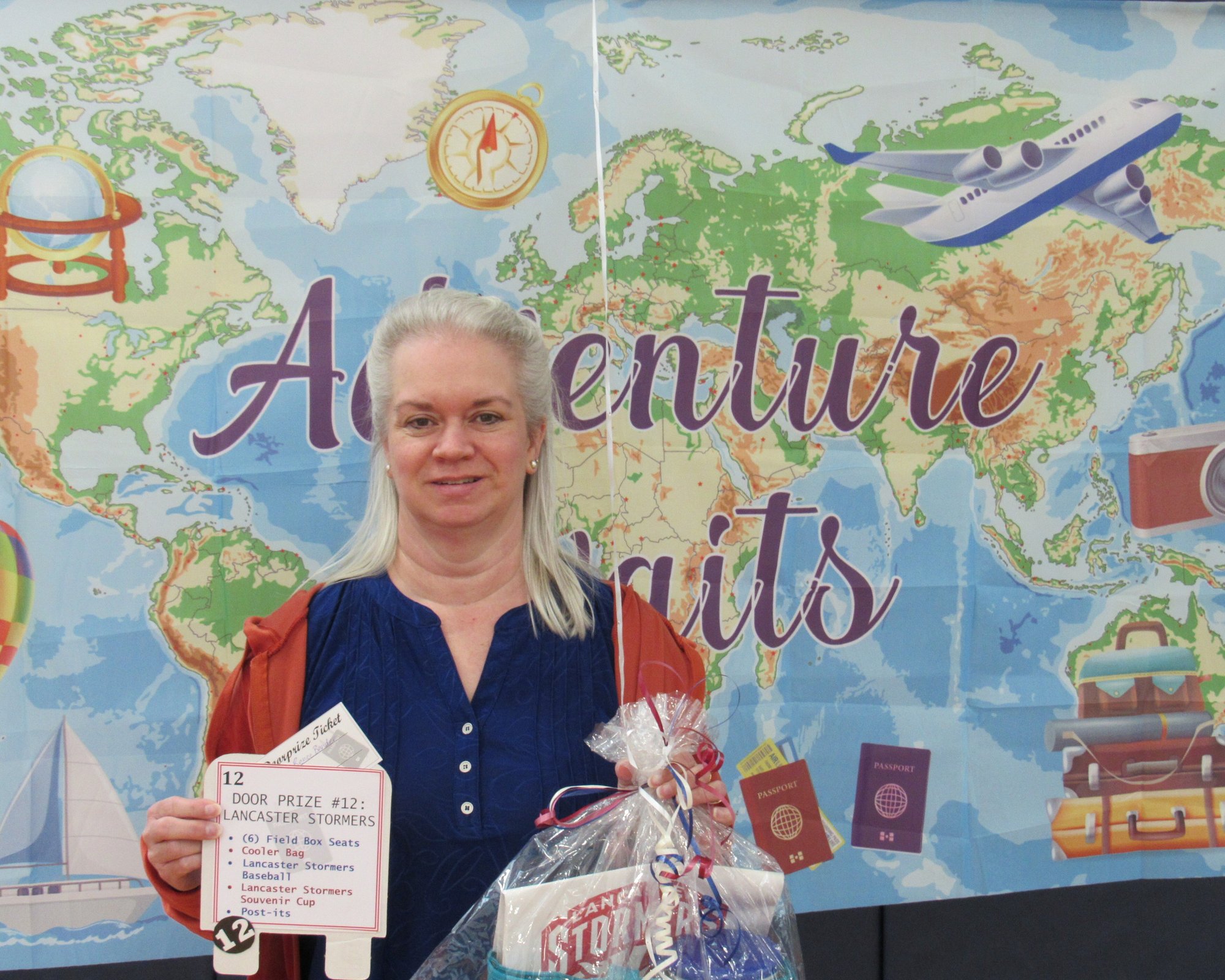 Smiling woman holding gift package in front of banner showing a map of the world. Smiling woman holding gift package in front of banner showing a map of the world.